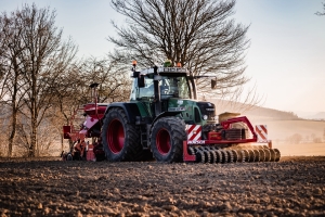 Traktor beim Feld bestellen