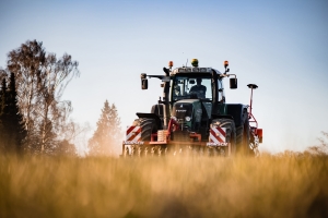 Traktor beim Feld bestellen