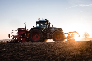 Traktor beim Feld bestellen