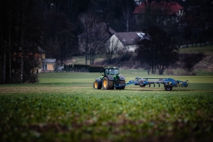 Traktor beim Feld bestellen