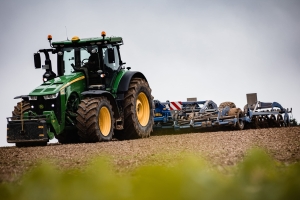 Traktor beim Feld bestellen