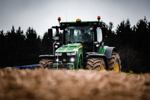 Traktor beim Feld bestellen