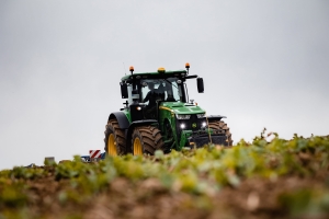 Traktor beim Feld bestellen